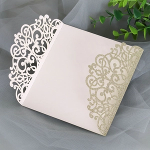 Detail of laser-cut ivory card with gold glitter finish for elegant wedding invitations