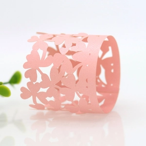 Detail of pink pearlescent paper napkin ring with a laser-cut cherry blossom floral pattern