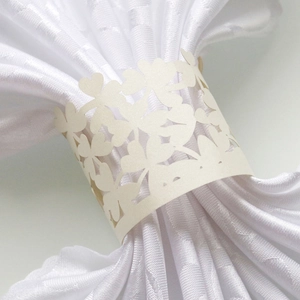 Detailed laser-cut heart and floral patterns on pearlescent paper napkin ring