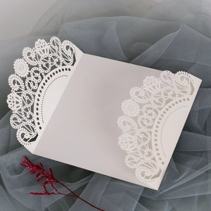 Elegant white laser cut wedding invitation with intricate floral lace patterns