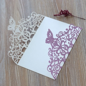 Detail of laser-cut butterfly invitations in cream matte and purple glitter finish