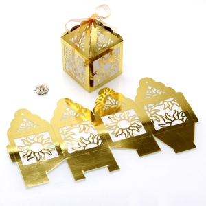 Detailed laser-cut gold paper gift box with sunburst pattern and matching ribbon bow