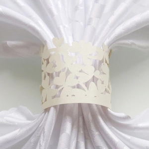 Detailed macro view of laser-cut clover pattern on cream-white pearlescent napkin ring