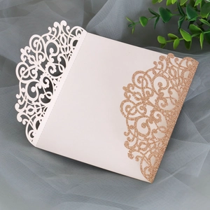 Detail of laser-cut ivory wedding invitation featuring elegant rose gold glitter edges
