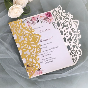 Detail of laser-cut wedding invitation with gold glitter and floral inner card