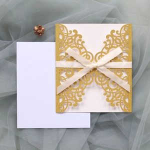 Detailed laser-cut glitter invitation card with elegant cream ribbon and blank insert