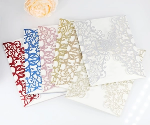 Close-up of laser-cut butterfly wedding invitations in multiple glittery metallic colors