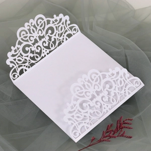 Détail d'invitation de mariage blanche découpée au laser avec motifs floraux élégants