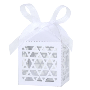 Detail of laser-cut white favor box with star patterns and a translucent ribbon bow