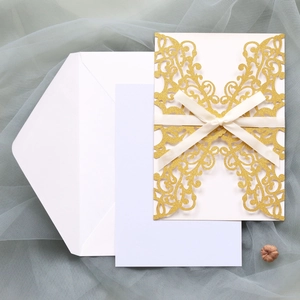Elegant gold glitter laser-cut wedding invitation set with white ribbon and envelope