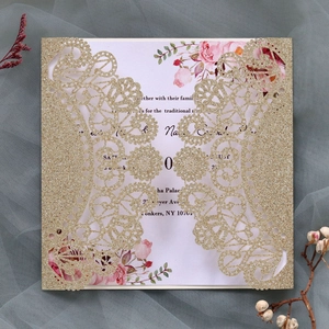 Detail of laser-cut lace pattern on gold glitter wedding invitation with floral insert