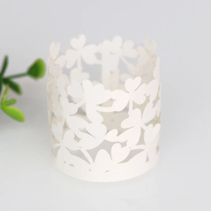 Detailed laser-cut white paper napkin ring with heart patterns for wedding party decor