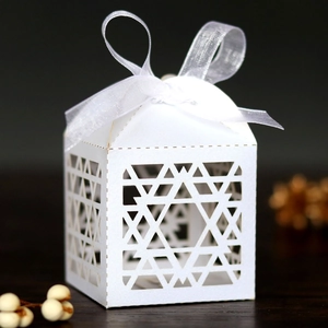 Close-up of Hanukkah gift box with laser-cut star pattern and white ribbon bow