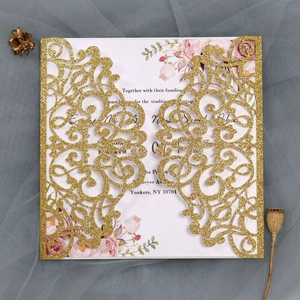 Macro view of laser-cut gold glitter wedding invitation with floral inner card details