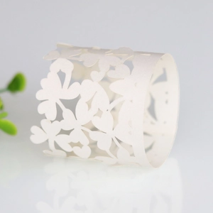 Detailed laser-cut pearl white napkin ring with hollow four-leaf clover and heart patterns