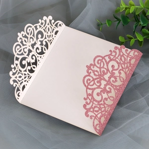 Detailed laser-cut floral pattern on elegant ivory invitation with pink glitter finish