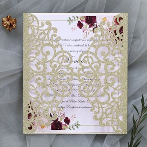 Detailed laser-cut gold glitter wedding invitation with floral inner card and lace patterns