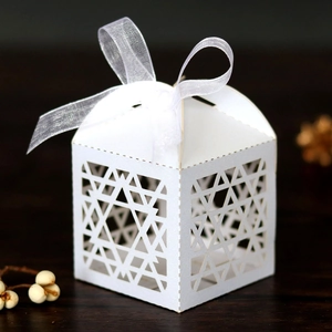 Macro detail of white Hanukkah favor box featuring laser-cut hexagram stars and organza ribbon