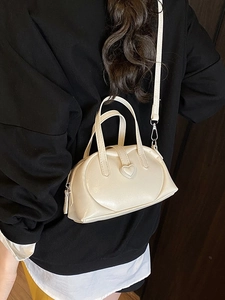Creamy white semi-circular handbag with heart detail and detachable shoulder strap