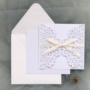 Invitation de mariage découpée au laser avec nœud crème et enveloppe assortie