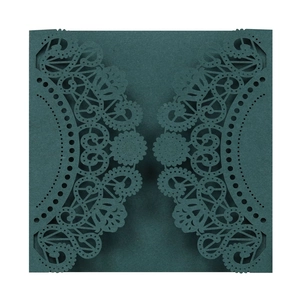 Macro view of laser-cut teal wedding invitation sleeve with detailed lace patterns