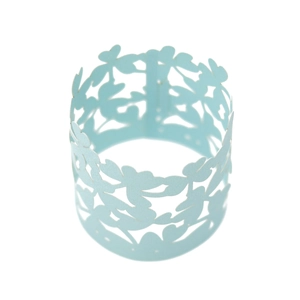 Detail showing the intricate laser-cut floral pattern on light blue paper napkin ring
