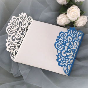 Detail of laser cut wedding invitation with blue glitter finish and scroll patterns