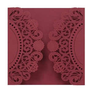 Detailed laser-cut lace pattern on a burgundy wedding invitation card sleeve