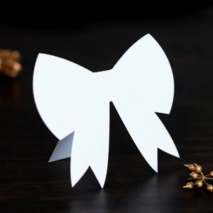 Elegant 3D white bow place card for weddings on dark wood background decoration