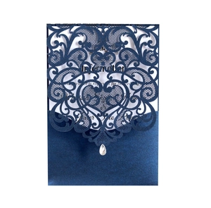 Detail of navy blue laser cut wedding invitation with lace pattern and crystal teardrop