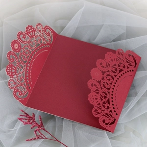 Detail of laser-cut lace pattern on a deep red elegant wedding invitation envelope
