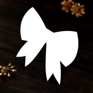 Macro shot of 3D white paper bow place card on dark wood with gold flowers