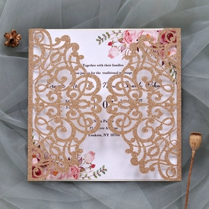 Macro detail of laser-cut wedding invitation with champagne gold glitter and floral inner card