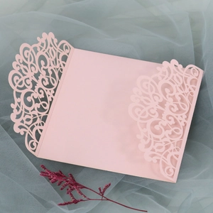 Vue détaillée de dentelle florale découpée au laser sur faire-part de mariage rose