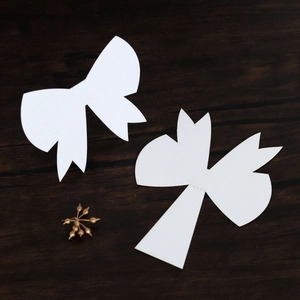 Macro view of white laser-cut 3D bow name cards for wedding table settings