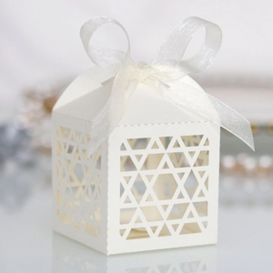 Close-up of white laser-cut Chanukah gift box with Star of David patterns and ribbon