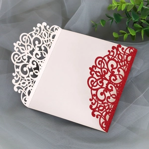 Detailed laser-cut scrollwork on cream and red glitter invitation card sleeve