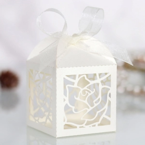 Detailed laser cut white rose favor box featuring an elegant organza ribbon bow