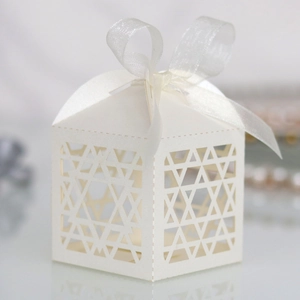 Close-up of laser-cut geometric star patterns on a gift box with a sheer ribbon bow