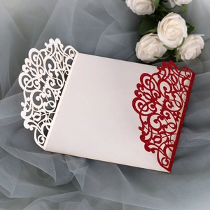Close-up of laser-cut floral pattern on wedding invitation with red glitter and white paper