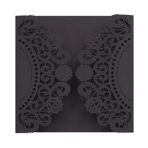 Close-up of laser-cut lace pattern and intricate details on the dark grey invitation cover