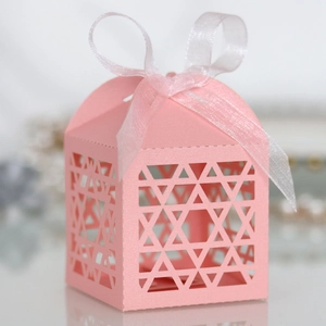 Detailed close-up of pink geometric cutout gift box with elegant white ribbon bow