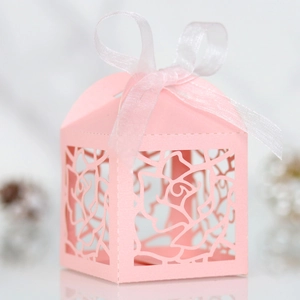 Detail of pink laser-cut rose hollow favor box with elegant white ribbon bow