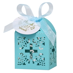 Light blue laser-cut wedding favor box with cross pattern and thank you tag with ribbon