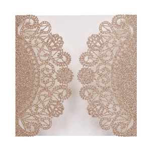 Macro view of laser-cut lace floral pattern on glitter rose gold wedding invitation