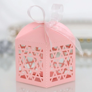 Pink paper favor box with star cutouts and white ribbon detail for party decor
