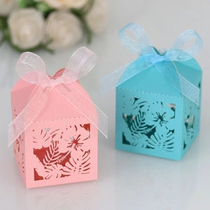 Laser-cut hibiscus leaf candy boxes in pink and blue with elegant silk ribbon bows