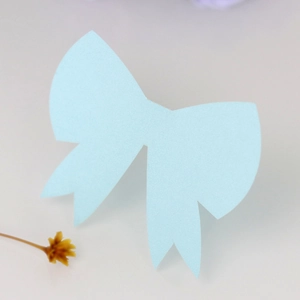 Close-up of light blue glitter paper bow card with texture for wedding table setting