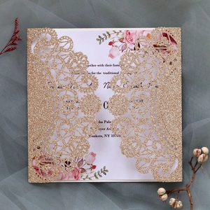 Macro detail of laser-cut glitter wedding invitation with elegant pink floral inner card
