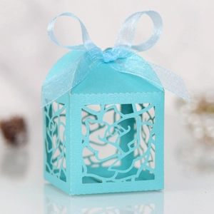 Detail of laser-cut rose patterns on elegant cyan candy gift box with silk ribbon